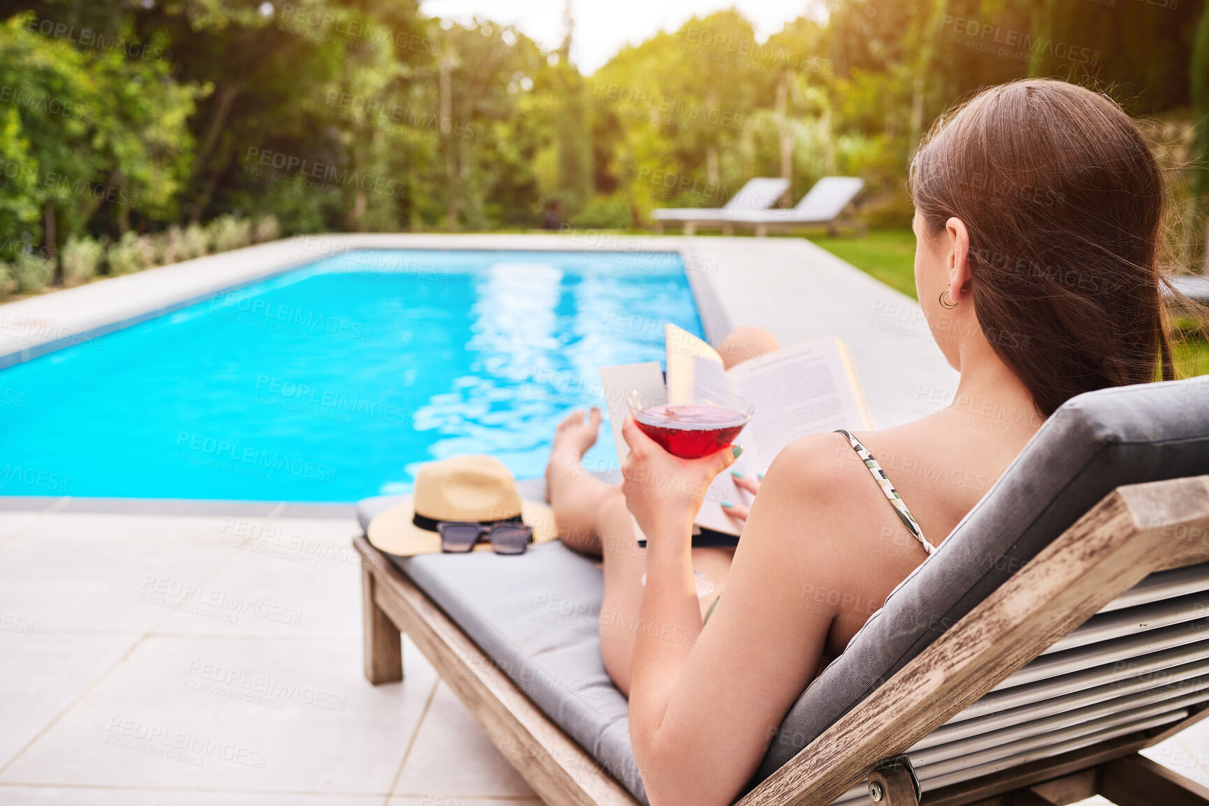 Buy stock photo Back, woman and cocktail at swimming pool for relax, wellness and freedom for luxury holiday. Water, reading and female person at resort or hotel for summer, travel and calm for vacation in Hamptons