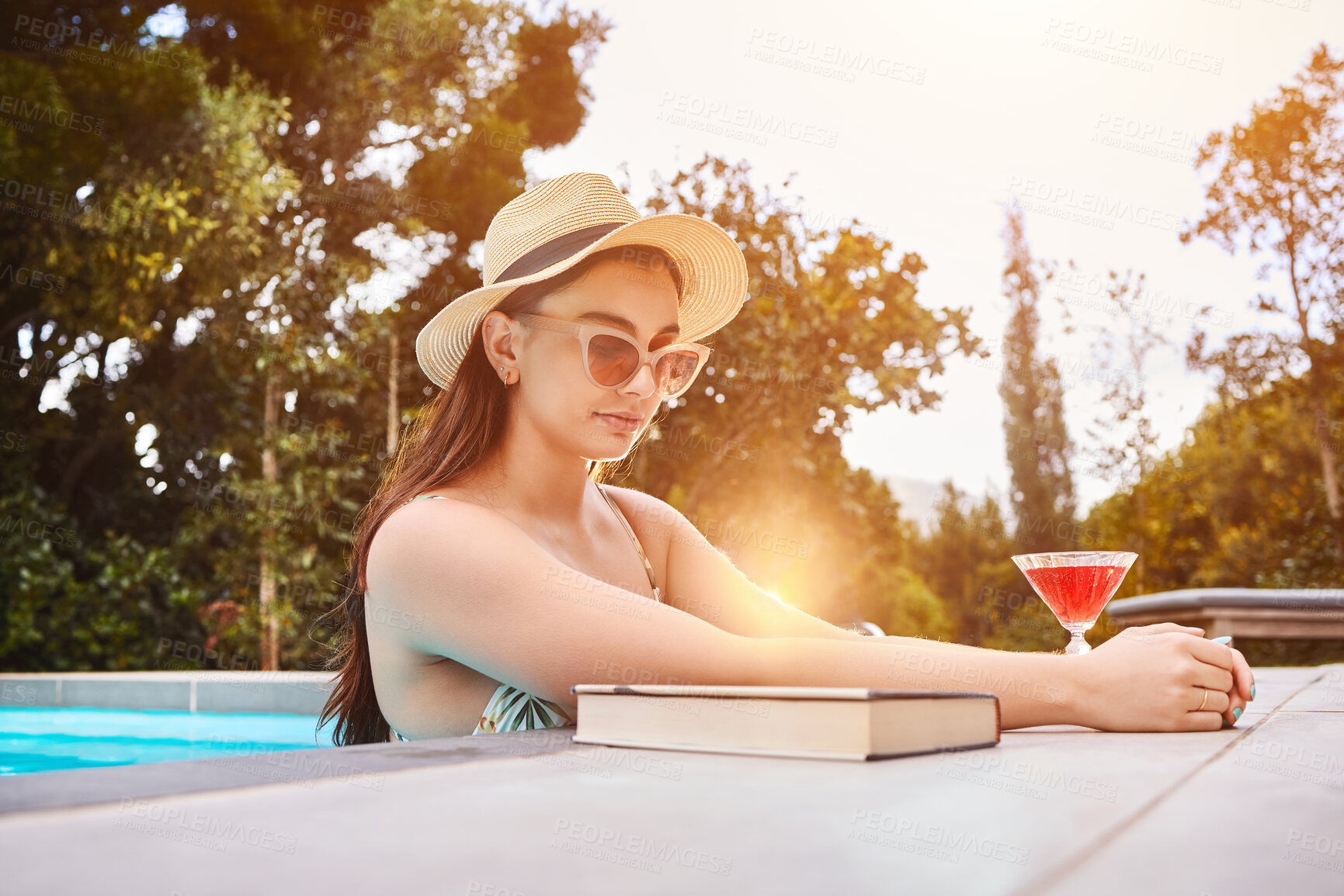 Buy stock photo Book, woman and cocktail at pool for swimming, hospitality and freedom for luxury holiday. Water, sunglasses and female person at resort or hotel for summer, travel and calm for vacation in Hamptons