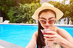Woman, happiness and drink by pool on vacation for wellness, relax outdoor at hotel with alcohol. Female person, sunglasses and cocktail at resort for peace on holiday, freedom or travel in Bali