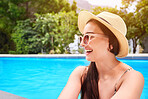 Happy, relax and woman in pool at resort for summer travel, vacation or weekend trip in Greece. Smile, swimming and female person with sunglasses and hat in water outdoor at holiday home or hotel.