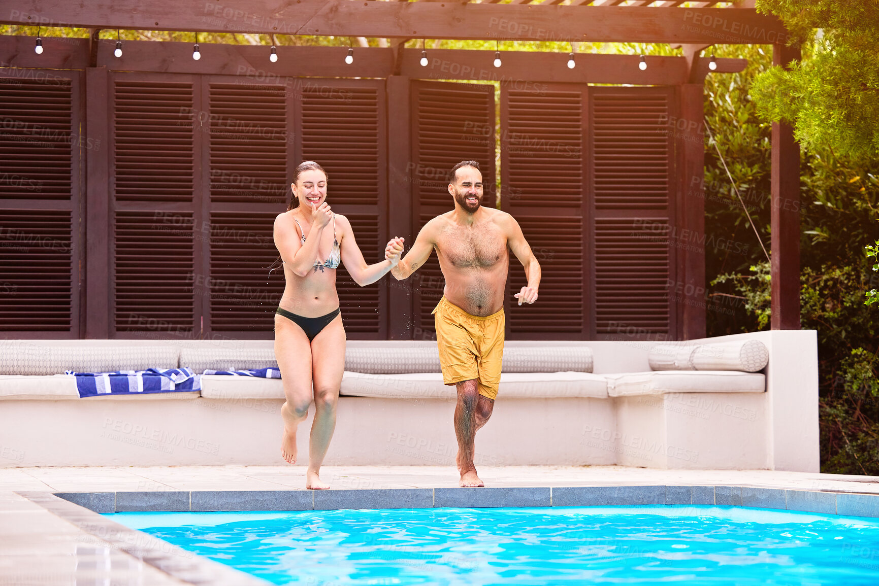 Buy stock photo Man, woman and holding hands at hotel by swimming pool for travel, jump on holiday for wellness. Couple, running and together with support for vacation in Bali, dive and bonding for relationship