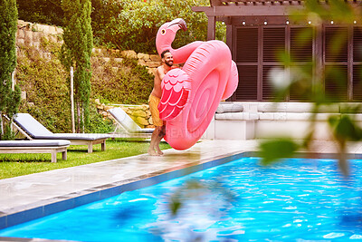 Buy stock photo Man, flamingo and fun at pool on holiday, luxury and enjoy the summer at resort. Pink float, swimming and ready for jump at water with excitement, vacation and energy on weekend trip to villa