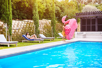 Buy stock photo Water, holiday and couple with inflatable in swimming pool for summer vacation, weekend break or getaway at resort. Relax, woman reading and happy man with flamingo float for fun, comfortable or jump