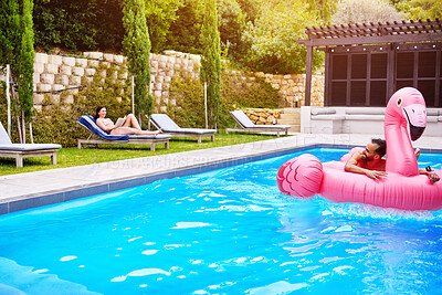 Buy stock photo Man, relax and swimming pool on float outdoor for inflatable flamingo, love and enjoy water on vacation resort. Smile, couple and floating for romance, poolside and bonding on summer holiday at villa
