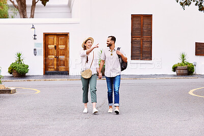 Buy stock photo Travel, walking and happy couple holding hands in street for sightseeing, summer vacation or adventure in city. Love, holiday and tourist man with woman pointing for date, trip or explore in Greece