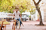 Happy couple, bicycle and ride with date in city for fun bonding, travel or outdoor holiday. Young man, woman or tourists enjoying day of cycling, leisure or activity together on bike in urban town
