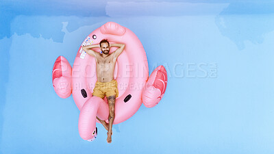 Buy stock photo Summer, relax and man on inflatable in swimming pool for vacation, holiday break or weekend getaway at resort. Aerial view, water and person on flamingo float for sunbathing, comfortable or happiness