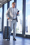 Corporate man, travel and networking in airport for communication and check schedule or agenda. Company director, walking and mobile in building for investment, trading and online weather update