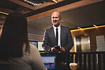Businessman, reservation and receptionist with laptop, desk and hotel for meeting, travel and networking. Check in, hospitality and professional person in resort, registration and communication