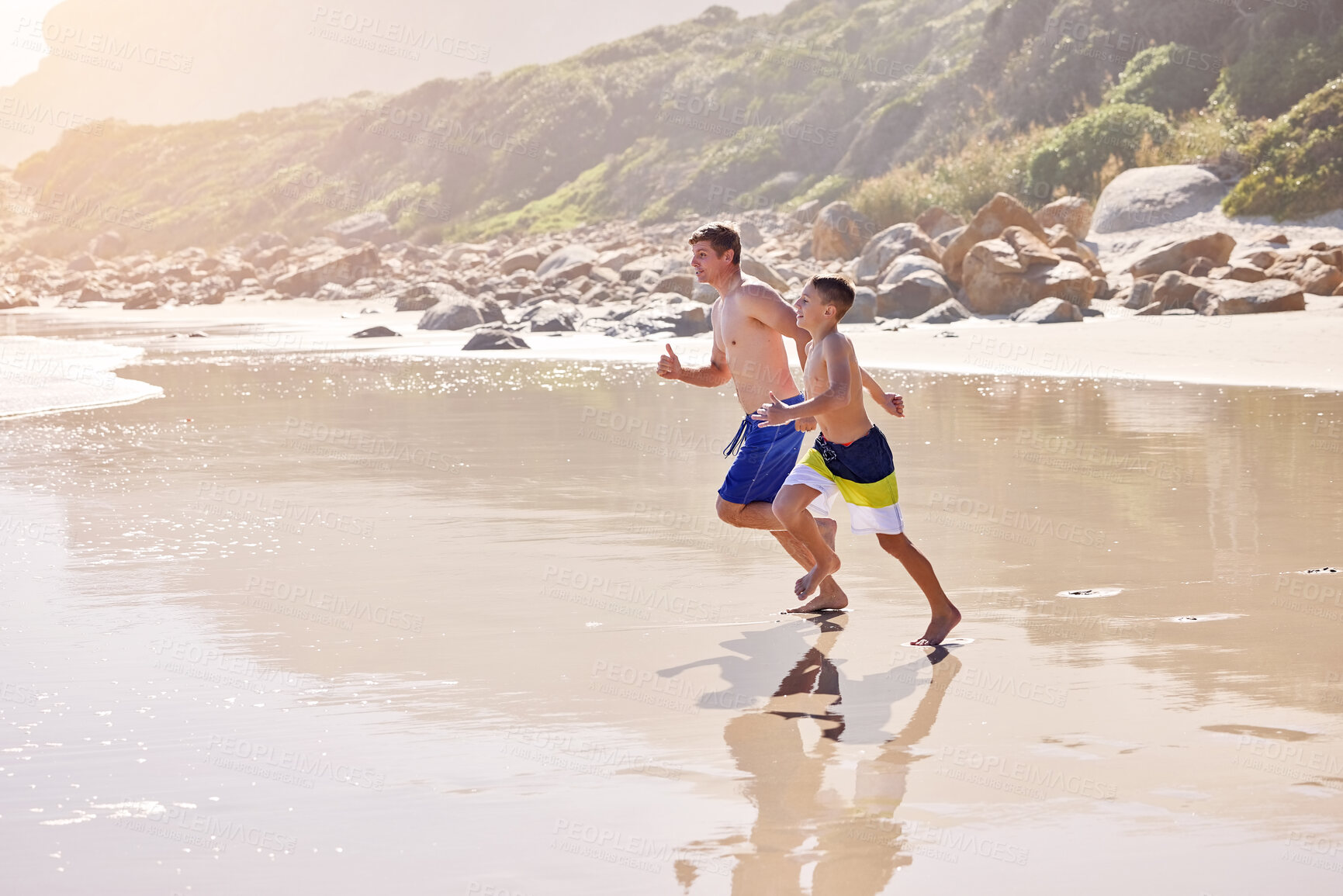 Buy stock photo Father, son and running at beach for vacation, bonding or love in summer, outdoor and together in nature. Dad, child and playful with care, holiday or people with family in sunshine by ocean in Spain