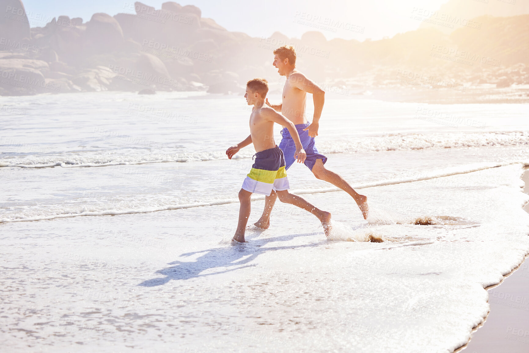 Buy stock photo Father, son and running at ocean for vacation, bonding or love in summer, outdoor and together in nature. Dad, child and playful with care, holiday or people with family in sunshine at beach in Spain