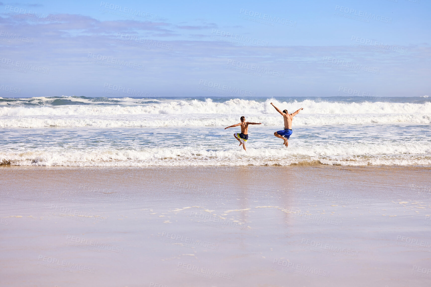 Buy stock photo Waves, kid and dad jump on beach with fun, travel and bonding together on tropical holiday adventure. Island, father and son running on summer vacation with ocean, happy play and sea water from back