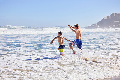 Buy stock photo Father, son and running at beach with waves, bonding or love in summer, vacation and together in nature. Dad, child and playful with care, holiday or people with family in sunshine by ocean in Spain