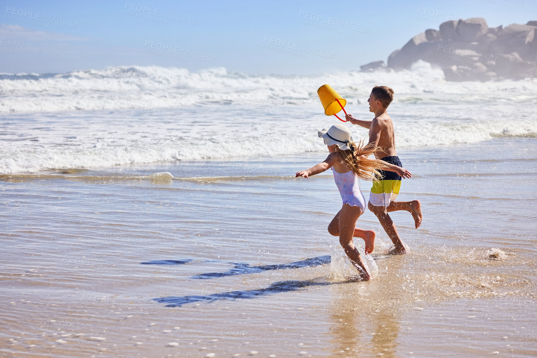 Buy stock photo Children, water and running with bucket at beach for playing with fun activity, summer holiday or race game. Kids, freedom and bonding on sand with tropical adventure, family vacation or plastic toys