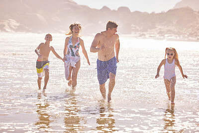 Buy stock photo Parents, children and running at travel, ocean and vacation with love, summer and happy in nature. Father, mother and kids with splash, holiday and outdoor with family in sunshine at beach in Spain