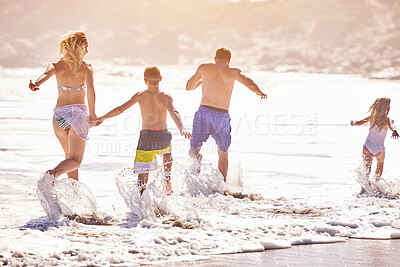 Buy stock photo Parents, children and splash in waves at beach for vacation, love or summer for running together in nature. Dad, child and playful with back, holiday or people with family in sunshine by sea in Spain