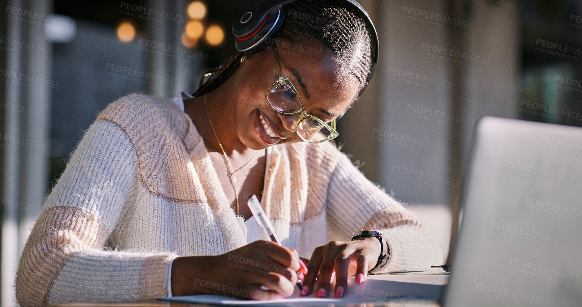 Buy stock photo Writing, headphones and black woman with laptop, smile and listen to audio, video editing and glasses. Outdoor, freelancer and content creation at cafe, online and creative for post production