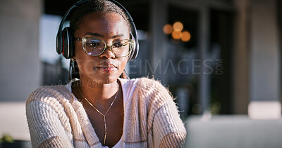 Buy stock photo Online, headphones and black woman with laptop, thinking and listening to audio, video editing and creative. Outdoor, freelancer and content creation at cafe, sound and ideas for post production