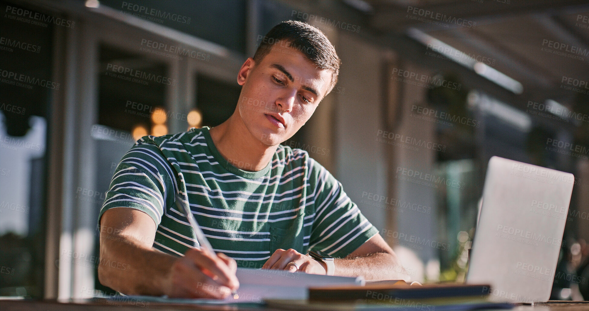 Buy stock photo Man, university student and outdoor with laptop or writing on notebook for assignment on campus. Male person, college learner and textbook for education with research or study for exam and assessment