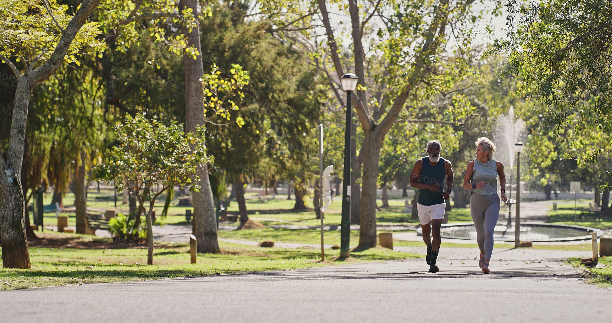 Buy stock photo Fitness, elderly couple and running in park for training, cardio exercise and wellness in retirement. Senior interracial people, smile outdoor or workout support, motivation or friends with energy