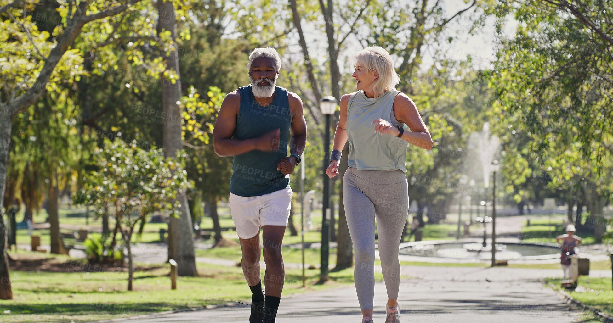 Buy stock photo Fitness, elderly couple and running in park for cardio, wellness exercise and training in retirement. Interracial people, seniors and outdoor for workout with support, motivation or smile with energy