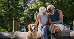 Mature couple, dog and park with phone and sitting in retirement with social media and pet. Morning, love and care of interracial relationship with smile, fitness break and tech with golden retriever