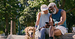 Mature couple, dog and park with phone and web scroll with social media and pet outdoor. Morning, love and space of interracial relationship with animal, fitness break and tech with golden retriever