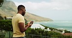 Balcony, phone and vacation with black man in mountain resort for holiday or travel to coast. Accommodation, adventure and journey with influencer person outdoor in nature location for tourism review