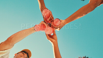 Buy stock photo Hands, drinks and toast with friends, low angle and blue sky with celebration, cheers or event in summer. People, bottle and soda with party, solidarity and vacation with success, achievement or goal