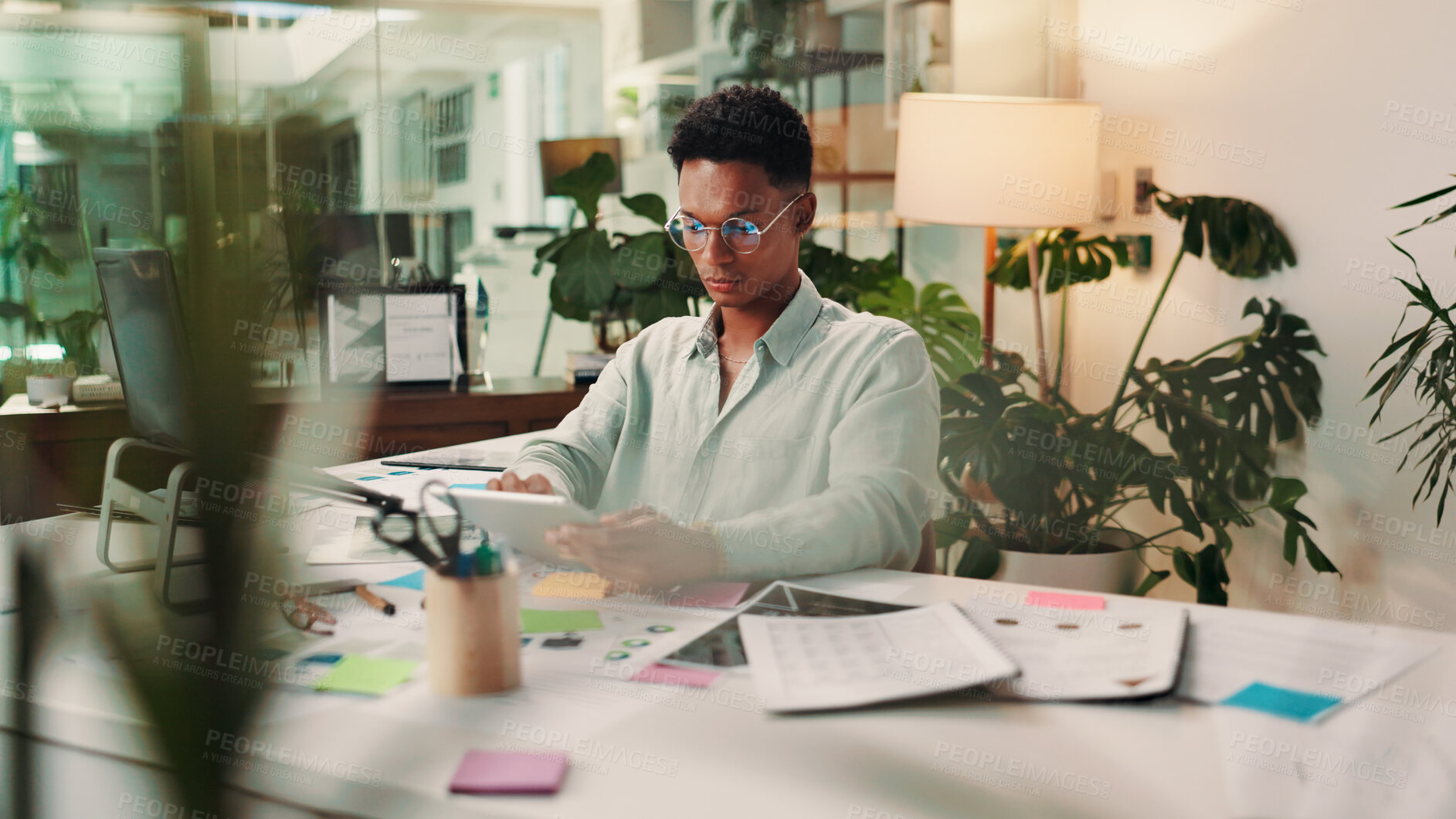 Buy stock photo Creative, night or man on tablet in startup for social media campaign, trends and business ads. App, late or content strategist in agency for online review, performance or branding design research