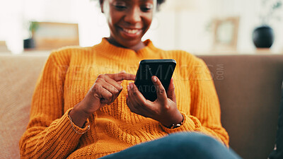 Buy stock photo Hands, phone and texting on sofa in home, contact or relax with scroll on web chat in living room. Black woman, smartphone and click on mobile app for notification, happy or social network in house
