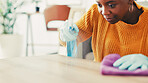 Housekeeping, spray bottle and black woman with cloth, cleaning and remove bacteria. Dust, apartment and African person in lounge, chore and routine with disinfectant, hygiene product or virus safety