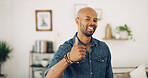 Portrait, black man and smile with thumbs up at house for agreement, thank you and good news. Happy, male person and yes with hand gesture, voting support and feedback for announcement in living room