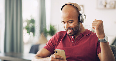 Buy stock photo Black man, phone and fist pump for success in home for good news, giveaway winner and celebration. Person, headphones and mobile for listening to music, podcast reward and achievement notification