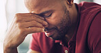 Sad, black man and crying with emotions at house with depression, mourning loss and bad news. Male person, grief and breakdown with past memory, trauma experience and mental health crisis in lounge