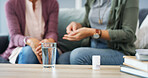 Hands, glass and pills with caregiver in home for patient, health and medicine with schedule in living room. People, water and drugs for wellness, supplements and benefits in lounge at apartment
