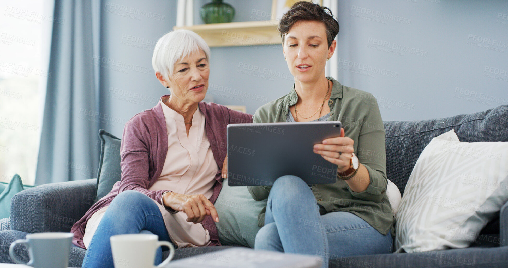 Buy stock photo Tablet, teaching and woman with senior mother on sofa for chatting, scrolling or networking. Digital technology, learning and female person helping elderly mom with online communication in home.