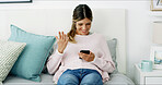 Woman, phone and texting with surprise on sofa, chat and check notification in living room at in home. Person, happy and shock with smartphone, mobile app and gossip on social network at apartment