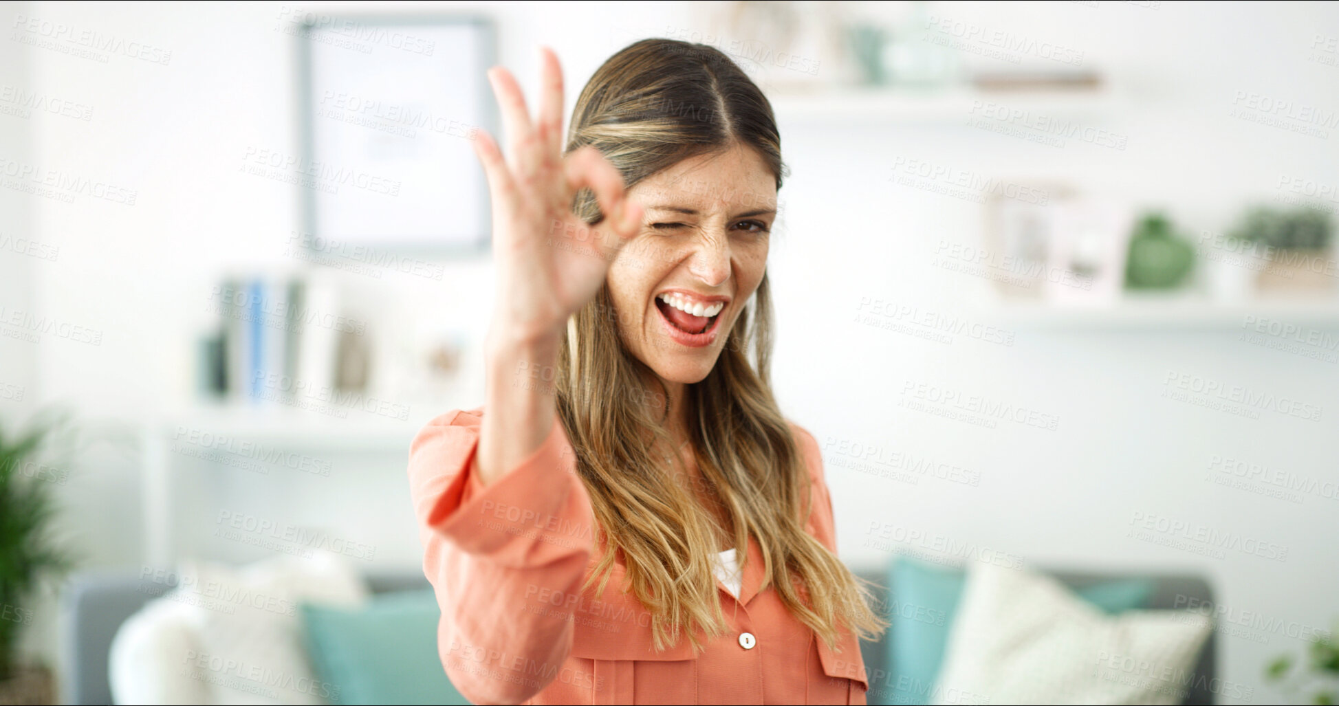 Buy stock photo Home, wink and woman with ok sign, portrait or like emoji with thank you in lounge. Face, apartment or happy person with pride, hand gesture or agreement with perfect symbol, icon and victory