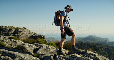 Buy stock photo Hiking, mountain and cliff with man in nature for fitness, travel adventure and workout. Blue sky, backpacking trip and exercise with person walking outdoor for trekking holiday, explore and peace