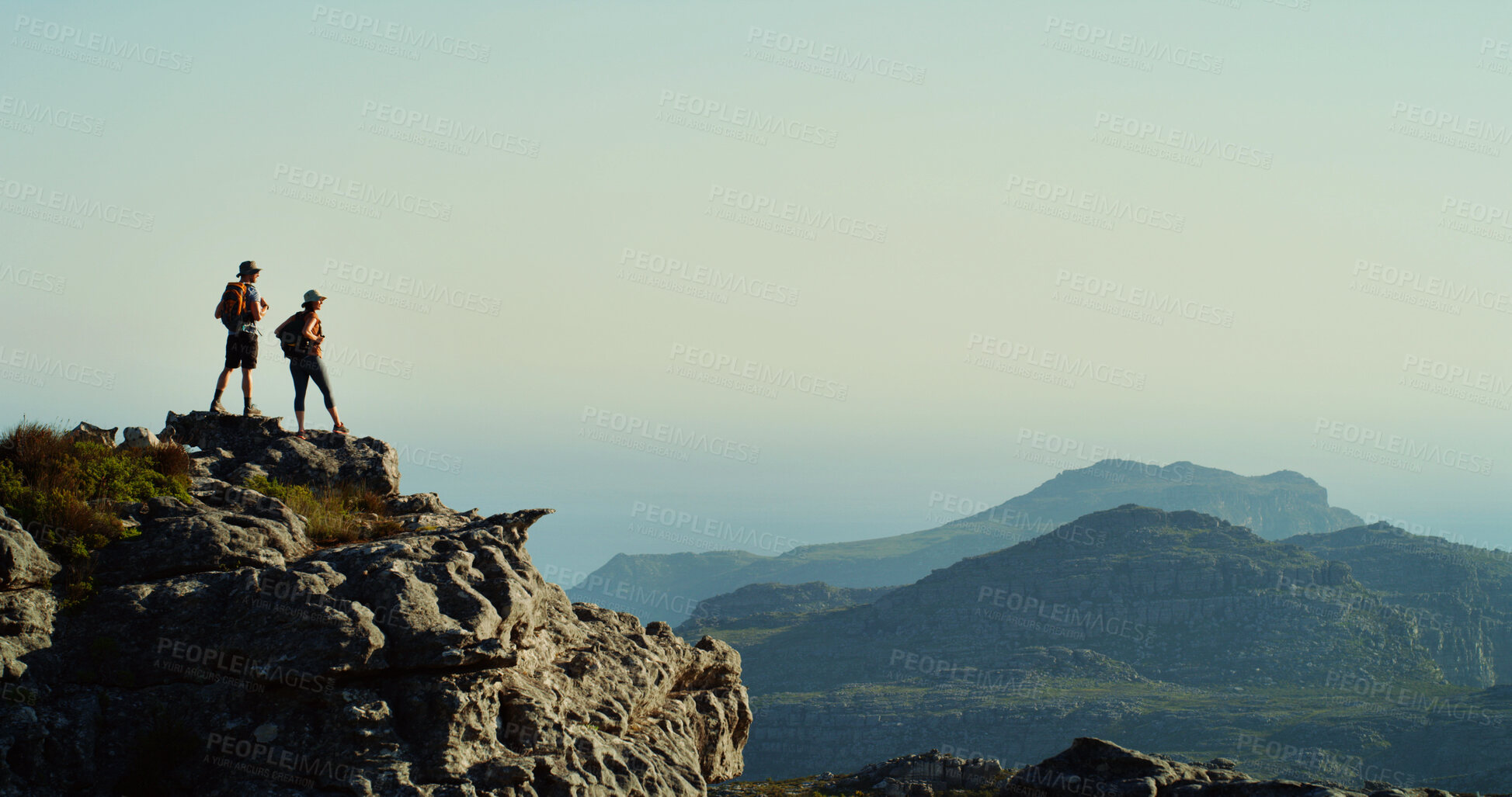 Buy stock photo Couple, hiker and mountain view with blue sky on cliff for hiking adventure or conquer in nature. Mockup space, tourist or explorer with bag, peak or horizon for trekking journey, trip or destination