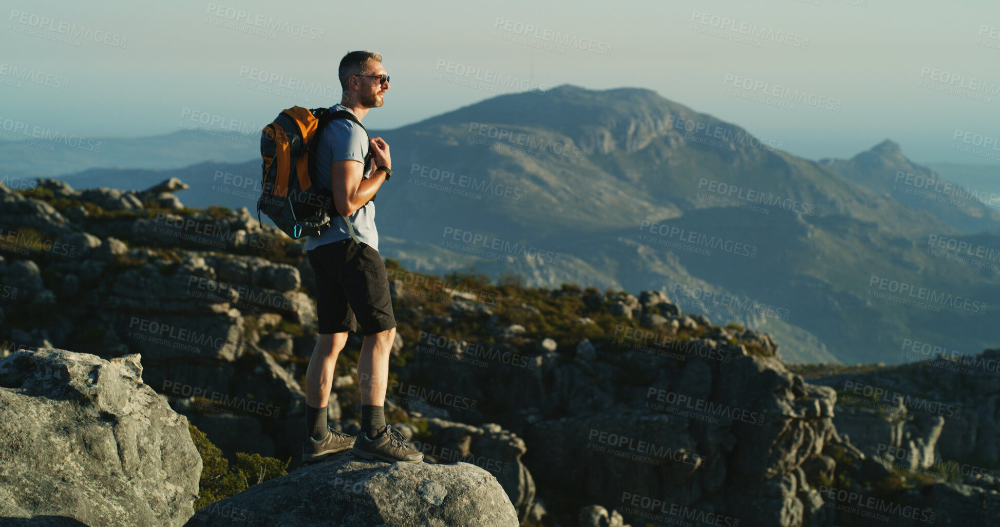 Buy stock photo Hiking, travel and walking with man on mountain for fitness, adventure and blue sky. Wellness, nature and thinking with person and outdoor view on cliff for trekking holiday, explore and mountains