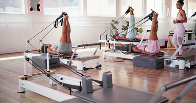Buy stock photo Pilates, exercise and personal trainer with people in class with reformer for training, workout and mobility. Fitness, gym and women with machine for stretching legs for wellness, health or challenge