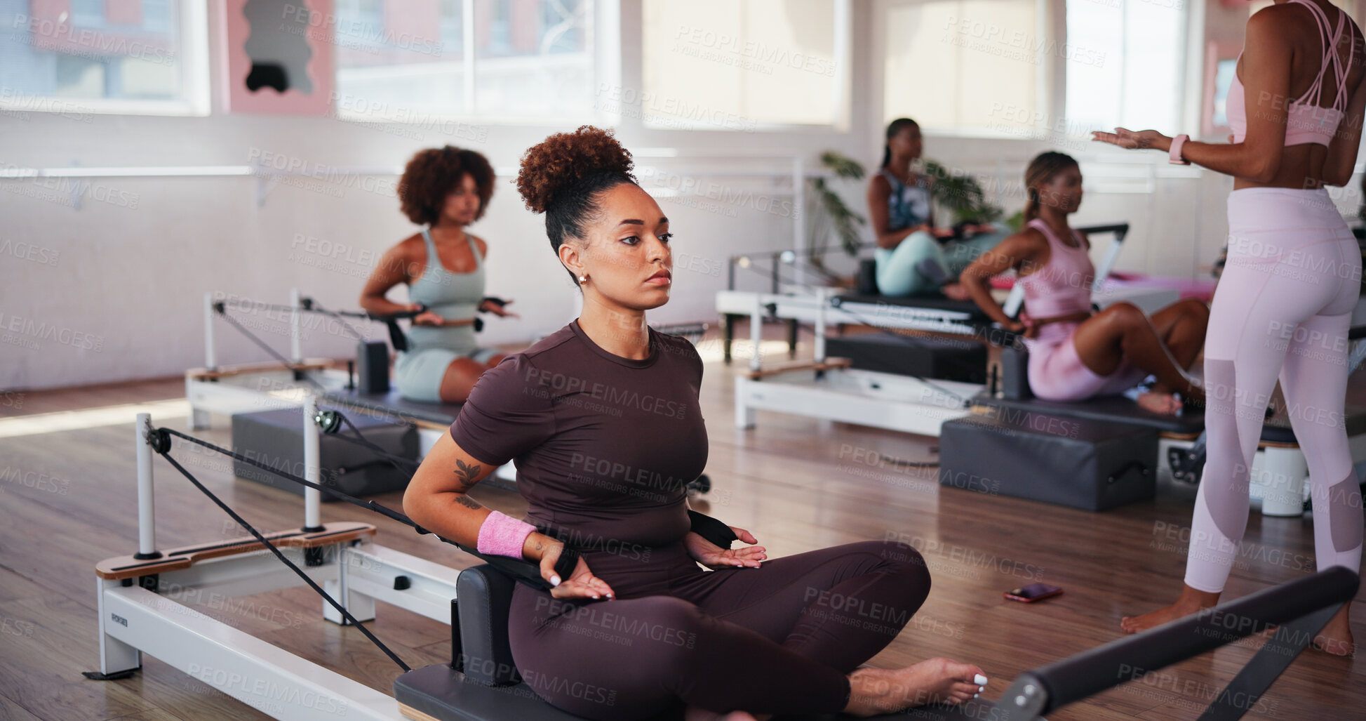 Buy stock photo Fitness, pilates and reformer with people in class for improvement, training or workout routine. Concentration, equipment and exercise with woman on machine in studio for challenge or performance