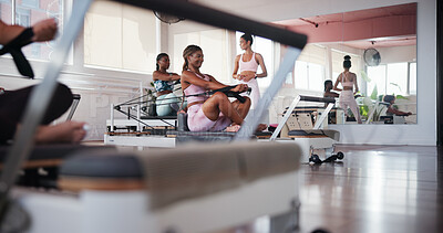 Buy stock photo Pilates, exercise and personal trainer in class with reformer for training, arm workout and mobility. Fitness, gym and women with machine for wellness, health and challenge for resistance in studio
