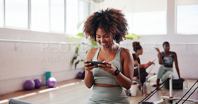 Buy stock photo Happy, woman and phone in pilates class for exercise break, watching online video or streaming service. Fitness, yogi and girl with smartphone at gym studio for yoga tutorial, wellness tips or health