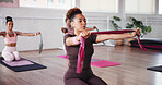 Exercise, pilates and resistance band with woman in studio for improvement, training or workout. Concentration, fitness and strength with people in gym class for challenge or performance routine