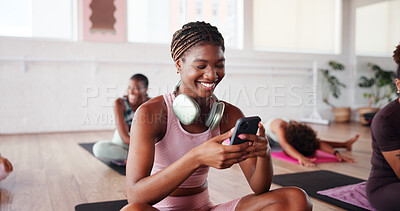 Buy stock photo Yoga, happy and woman with phone in studio for exercise break, checking notifications or social media. Fitness, yogi and girl with smartphone at pilates class for research, mobile chat and headphones
