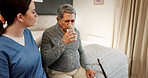 Drinking water, senior man and caregiver in nursing home, help and thirsty in bedroom and hydration. Healthcare, nurse and old person with liquid for medication, rehabilitation and woman with patient