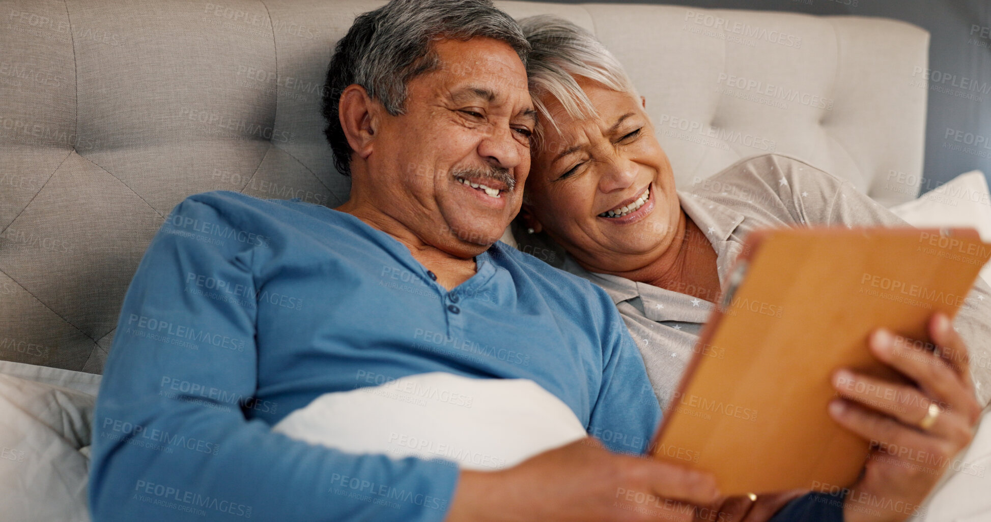 Buy stock photo Bedroom, senior couple and happiness with tablet for streaming comedy, reading news and entertainment. Old people, man and woman with laugh for digital joke, funny video or bonding in morning at home